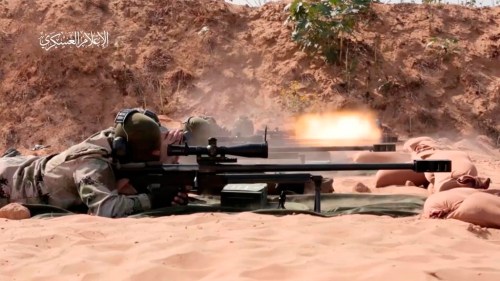 This image from video posted by Hamas on Dec. 20, 2023, purports to show Hamas militants using domestic copies of the AM-50 Sayyad, an Iranian-made a sniper rifle that fires a .50- caliber round powerful enough to punch through up to an inch of steel. Experts interviewed by The Associated Press said it would be nearly impossible for Hamas to manufacture a safe and accurate sniper rifle using the rudimentary equipment shown in the video. Watermark at upper left reads “military media.” (Hamas via AP)