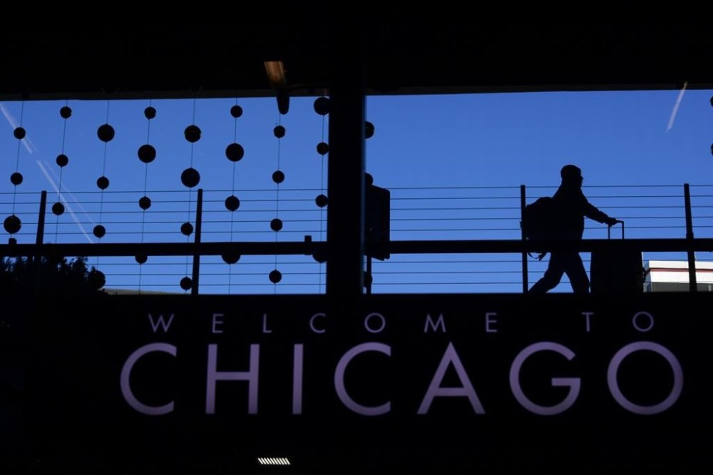 FILE - A passenger walks with luggage past holiday decorations at Chicago O'Hare International Airport, Dec. 24, 2022, in Chicago. A plane taxiing for departure clipped another aircraft at Chicago O'Hare International Airport on Sunday evening, Jan. 14, 2024, the Federal Aviation Administration said Monday, Jan. 15. (AP Photo/Paul Beaty, File)