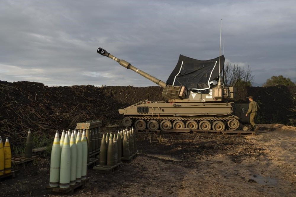 An Israeli soldier walks to a mobile howitzer in the north of Israel, near the border with Lebanon, Monday, Jan. 15, 2024. AP Photo/Ohad Zwigenberg)