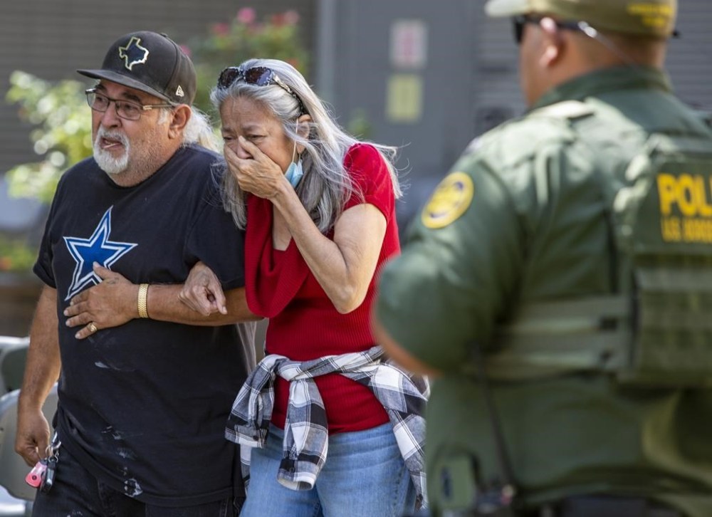 FILE - A woman cries as she leaves the Uvalde Civic Center, Tuesday May 24, 2022, in Uvalde, Texas, after a mass shooting. AA federal report into the halting and haphazard law enforcement response to a school shooting in Uvalde, Texas, was scheduled to be released Thursday, Jan. 18, 2024, reviving scrutiny of the hundreds of officers who responded to the 2022 massacre but waited more than an hour to confront and kill the gunman. (William Luther/The San Antonio Express-News via AP, File)
