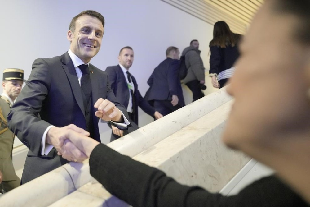 France's President Emmanuel Macron, centre, shakes hands as he arrives to the Annual Meeting of World Economic Forum in Davos, Switzerland, Wednesday, Jan. 17, 2024. The annual meeting of the World Economic Forum is taking place in Davos from Jan. 15 until Jan. 19, 2024.(AP Photo/Markus Schreiber)