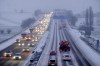 A salt truck drives on a snow covered highway in Frankfurt, Germany, after snow fall, early Thursday, Jan. 18, 2024. (AP Photo/Michael Probst)