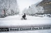 A person cycles past a road closed sign during a snowstorm in Vancouver Wednesday, Jan. 17, 2024. A winter storm closed schools and disrupted flights in B.C. on Wednesday, with snow expected to continue in some parts of the province.THE CANADIAN PRESS/Ethan Cairns
