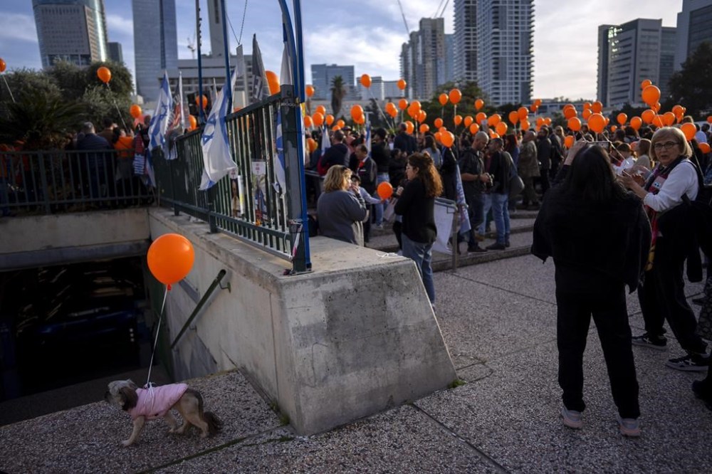 Demonstrators hold orange balloons at a rally in solidarity with Kfir Bibas, an Israeli boy who spent his first birthday Thursday in Hamas captivity in the Gaza Strip, in Tel Aviv, Israel, Thursday, Jan. 18, 2024. The plight of Bibas, the youngest hostage held by Hamas, has captured the nation's attention and drawn attention to the government's failure to bring home more than 100 hostages still held by Hamas after more than three months of war. (AP Photo/Oded Balilty)
