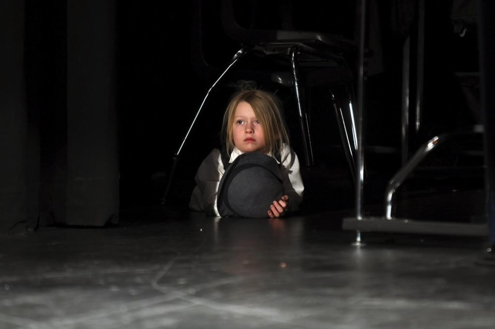 Rowan Bradley watches from the side of the stage while fellow actors perform “The Bullying Collection” at Wheatland High School in Wheatland, Wyoming on Friday, Jan. 12, 2024. School officials canceled the middle school play in part because it mentioned a gay character. The anti-bullying play was nonetheless performed under private sponsorship. (AP Photo/Thomas Peipert)