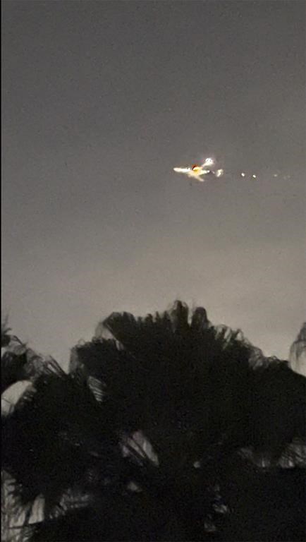 This image taken from video provided by Melanie Adaros shows sparks shooting from a cargo plane before making an emergency landing at Miami International Airport on Thursday, Jan. 18, 2024 in Miami. The aircraft landed safely Thursday night “after experiencing an engine malfunction soon after departure,