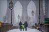 FILE - People walk down the Brooklyn Bridge during a snow storm on Saturday, Jan. 29, 2022, in New York. January can be the worst month for respiratory illnesses and vaccination rates are low. When relatives, friends and co-workers are coming down with coughs, nasal congestion, fatigue and fever, keeping viruses at bay means thorough hand-washing, good ventilation and wearing a mask in crowded areas. (AP Photo/Brittainy Newman, File)