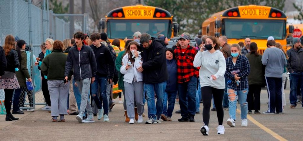 Parents walk away with their kids from the Meijer's parking lot, where many students gathered following an active shooter situation at Oxford High School, Nov. 30, 2021, in Oxford, Mich. The mother of a Michigan school shooter is headed to trial on involuntary manslaughter charges. Prosecutors are trying to pin criminal responsibility on Ethan Crumbley's parents in the deaths of four students at Oxford High School in 2021. Jennifer and James Crumbley are not accused of knowing their son planned to kill fellow students. But prosecutors say they were grossly negligent by making a gun accessible to Ethan Crumbley and ignoring his mental health needs. (Eric Seals/Detroit Free Press via AP, file)