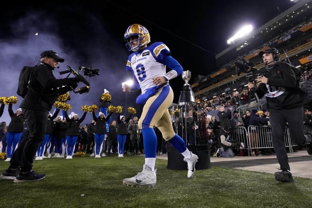 Collaros runs past the Grey Cup as he takes the field ahead of the 110th CFL Grey Cup against the Montreal Alouettes in Hamilton, Ont., in 2023. THE CANADIAN PRESS/Frank Gunn