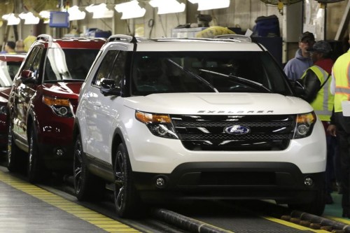FILE - Workers perform final inspections on vehicles, as 2015 Ford Explorers, right, roll off the assembly line at the Chicago Ford Assembly Plant in Chicago, Oct. 22, 2014. Ford is recalling nearly 1.9 million Explorer SUVs in the U.S. because a trim piece can fly off and create a hazard for other drivers. (AP Photo/M. Spencer Green, File)