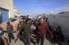 Palestinians carry a a body of a person killed in the Israeli bombardment at a building of an UNRWA vocational training center which displaced people use as a shelter in Khan Younis, southern Gaza Strip, Wednesday, Jan. 24, 2024. (AP Photo/Ramez Habboub)