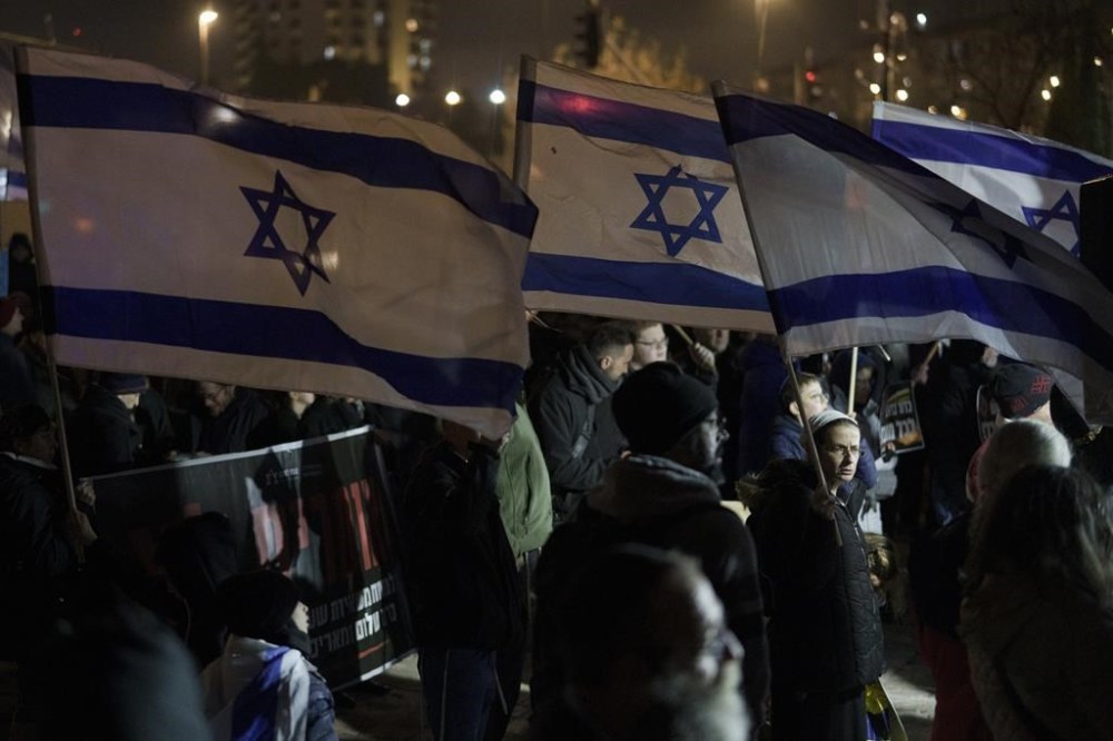 Holding up Israeli flags people take part in a protest against humanitarian aid entering Gaza and against the hostages exchange deal with Hamas, in Jerusalem, Israel, Thursday, Jan. 25, 2024. (AP Photo/Leo Correa)