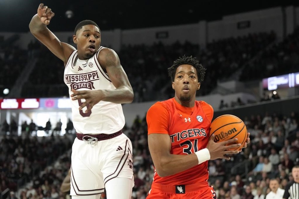 Auburn guard Chaney Johnson (31) pulls down a rebound past Mississippi State guard Shawn Jones Jr. (5) during the first half of an NCAA college basketball game, Saturday, Jan. 27, 2024, in Starkville, Miss. (AP Photo/Rogelio V. Solis)