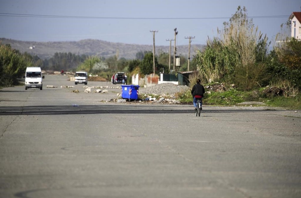 FILE - A woman rides a bicycle on a former runway of a military airport, now used as a road, in Gjader, northwestern Albania, Tuesday, Nov. 7, 2023, one of two proposed places to house migrants. Albania’s Constitutional Court on Monday Jan. 29, 2024 said a deal can go ahead with Italy under which thousands of migrants rescued at sea by Italian authorities would be sent to Albania while their asylum applications are processed. (AP Photo/Armando Babani, File)