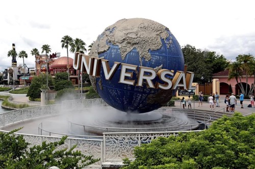 FILE - In this Aug. 5, 2019 file photo, guests cool off under a water mist by the globe at Universal Studios City Walk at Universal Studios Florida in Orlando, Fla. Universal Orlando Resort's new theme park opening next year will feature lands devoted to Super Nintendo World characters, the “Fantastic Beasts” films and the “How to Train Your Dragon” film franchise, theme park officials said Tuesday, Jan. 30, 2024. At the center of what will be Universal Orlando's fourth theme park, Universal Epic Universe, will be Celestial Park, a multi-acre space of gardens, waterways and pathways for strolling, Universal officials said in a news release. (AP Photo/John Raoux, file)
