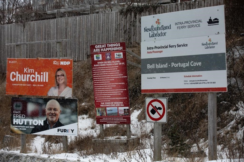 A person walks past signs for the provincial byelection in the riding of Conception Bay East-Bell Island, in N.L., on Monday, Jan.29, 2024. The Newfoundland and Labrador Liberals have won a byelection in district west of St. John's that was long held by the provincial Progressive Conservative party. THE CANADIAN PRESS/Paul Daly