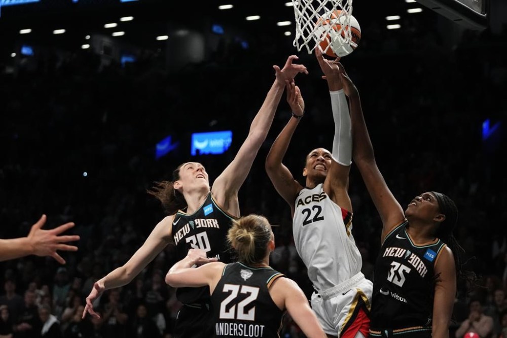 FILE - New York Liberty's Jonquel Jones (35), Courtney Vandersloot (22) and Breanna Stewart (30) defend a shot by Las Vegas Aces' A'ja Wilson (22) during the second half in Game 4 of a WNBA basketball final playoff series Wednesday, Oct. 18, 2023, in New York. New York assigned a franchise tag to Stewart a few weeks ago and is set to bring back free agent center Jonquel Jones according to a person familiar with the deal, as WNBA free agency tipped off Thursday, Feb. 1, 2024. (AP Photo/Frank Franklin II, File)