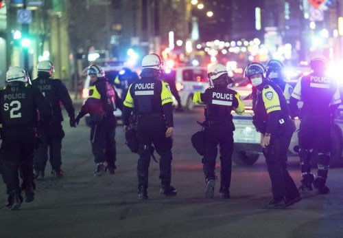 Police patrol Ste-Catherine Street in Montreal, Monday, April 12, 2021, during an 8 p.m. curfew imposed by the Quebec government to help curb the spread of COVID-19, as the COVID-19 pandemic continues in Canada and around the world. THE CANADIAN PRESS/Graham Hughes