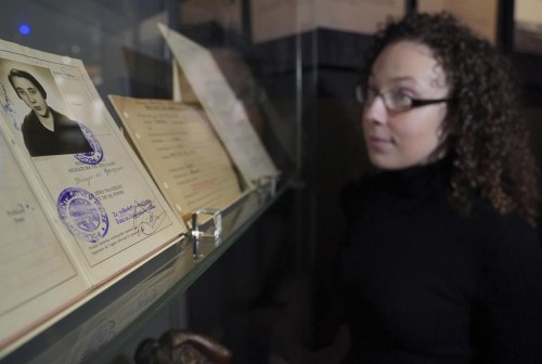 A member of National Archives staff looks at artefacts including the passport of then art student and German refugee Margarete Klopfleisch, amongst other documentation pertaining to her internement on the Isle of Man in 1940, on display as part of the Great Escapes: Remarkable Second World War Captives exhibition at the National Archives, in Kew, Richmond, England, Tuesday, Jan. 30, 2024. A new exhibit that opened Friday Feb. 2, 2024 at The National Archives in London uses the 80th anniversary of the so-called Great Escape by allied airmen from a German prisoner of war camp to explore escapes by captives of all kinds during World War II. (Jonathan Brady/PA via AP)