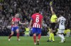 Referee Jose Maria Sanchez Martinez shows the yellow card to Atletico Madrid's Saul, left, during the Spanish La Liga soccer match between Real Madrid and Atletico Madrid at the Santiago Bernabeu stadium in Madrid, Spain, Sunday, Feb. 4, 2024. (AP Photo/Bernat Armangue)