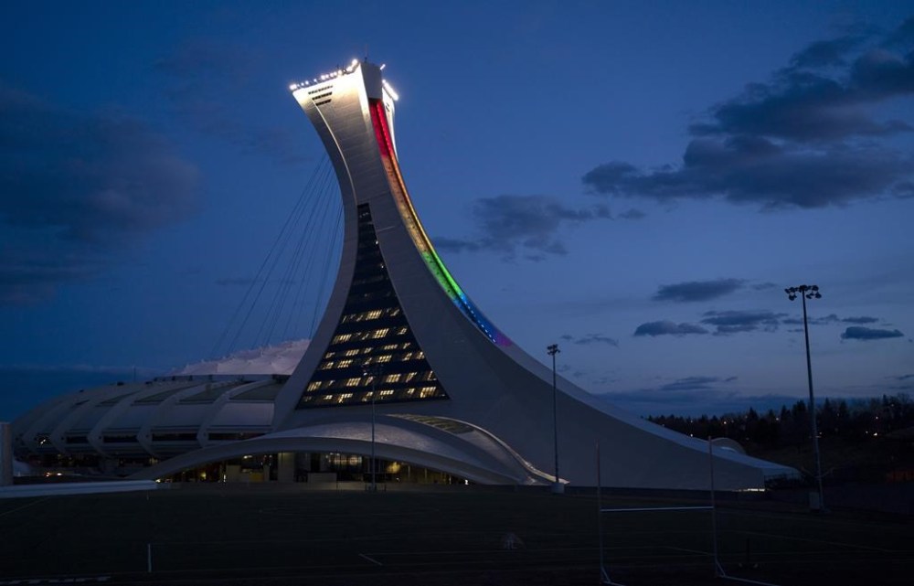 Quebec Tourism Minister Caroline Proulx says the provincial government will spend $870 million to replace the decaying roof of Montreal's Olympic Stadium. The Olympic Stadium is lit to the colours of the rainbow in solidarity with health-care workers in Montreal, on Monday, April 6, 2020. THE CANADIAN PRESS/Paul Chiasson