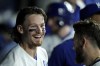 FILE - Kansas City Royals' Bobby Witt Jr. celebrates in the dugout with teammates after hitting a grand slam during the fifth inning of a baseball game against the Seattle Mariners Tuesday, Aug. 15, 2023, in Kansas City, Mo. The Kansas City Royals and shortstop Bobby Witt Jr. agreed Monday to the longest contract in franchise history, an 11-year pact that includes three years of team options that could keep the rising star with the ballclub through the 2037 season.(AP Photo/Charlie Riedel, File)