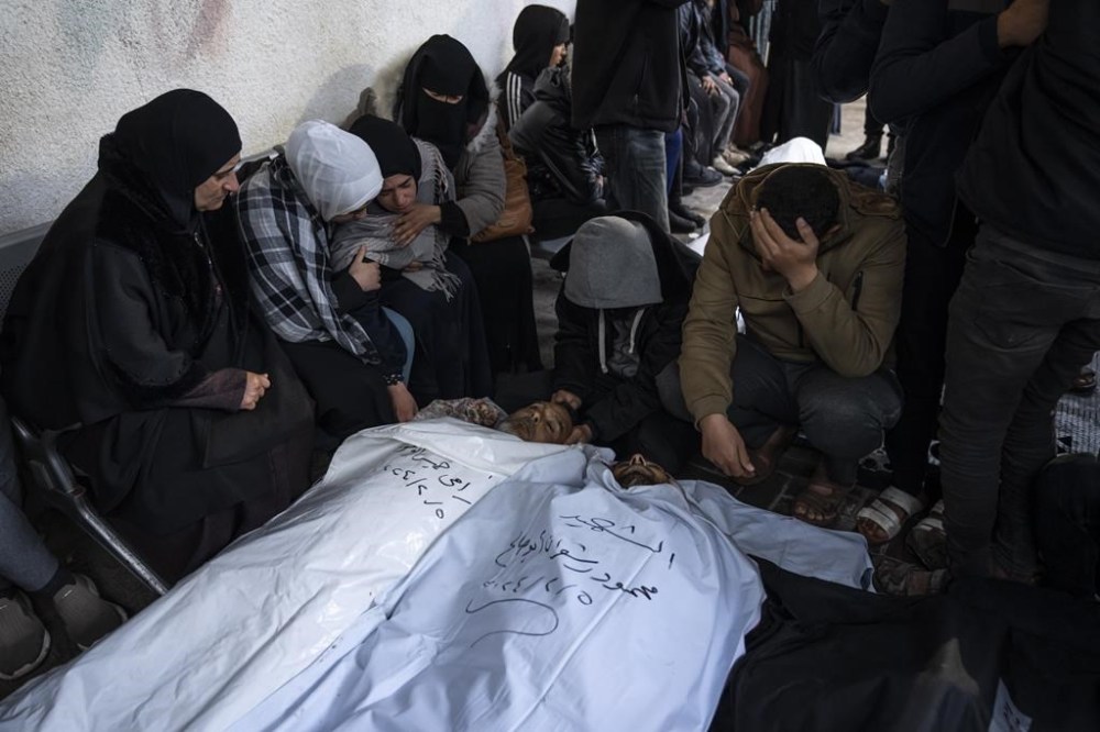 Palestinians mourn their relatives, killed in the Israeli bombardment of the Gaza Strip, outside a morgue in Rafah, southern Gaza, Tuesday, Feb. 6, 2024. (AP Photo/Fatima Shbair)