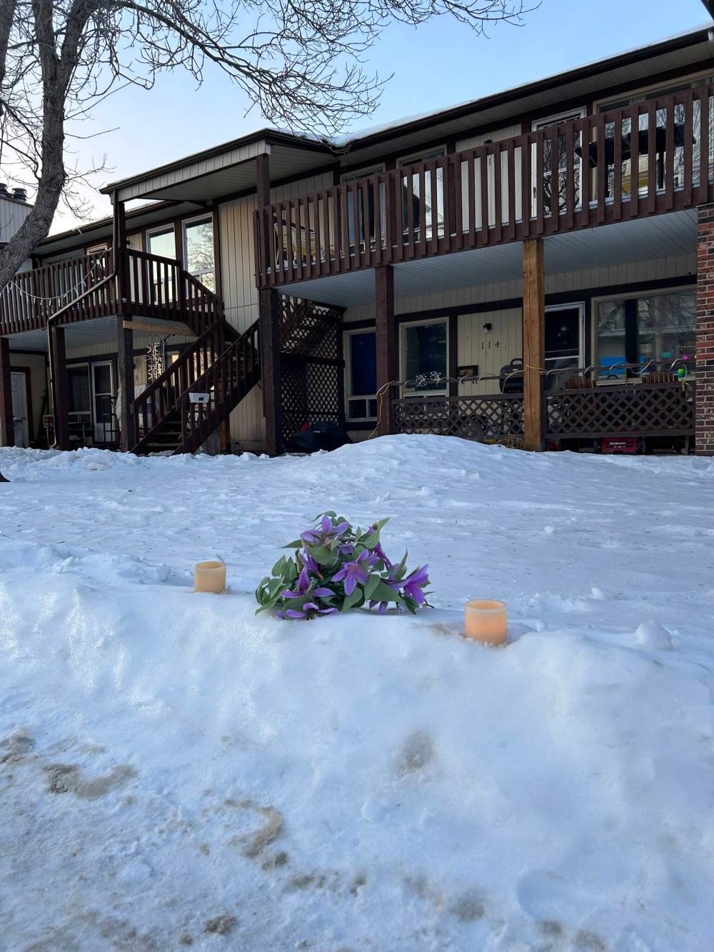 A bouquet of flowers and pair of electric candles marked the spot where a 35-year-old man was arrested by police at an apartment complex in the 200 block of Fairlane Avenue early Saturday morning. The man later died in the hospital and the IIU is investigating. (Tyler Searle / Winnipeg Free Press)