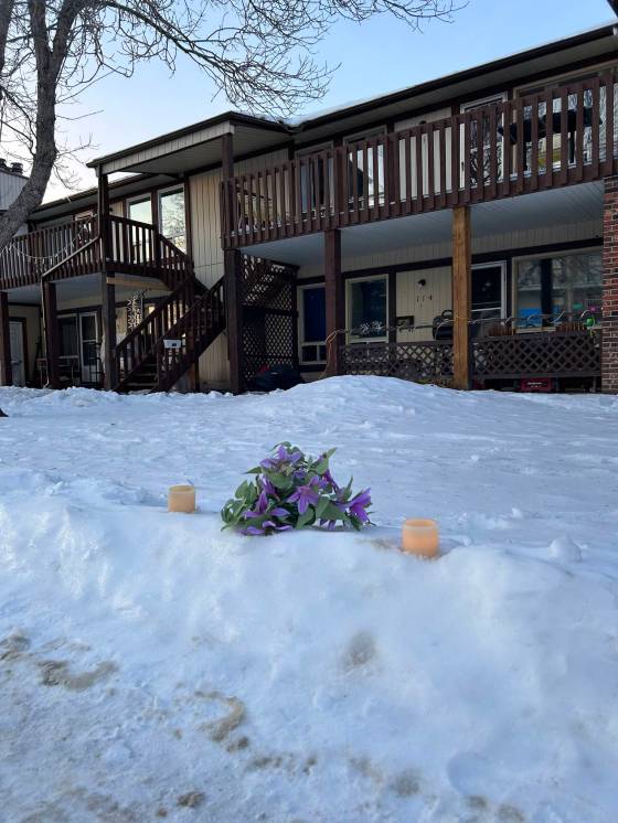 Flowers and electric candles mark the spot where a 37-year-old man was arrested by police in the 200 block of Fairlane Avenue. The man later died in the hospital. (Tyler Searle / Winnipeg Free Press)