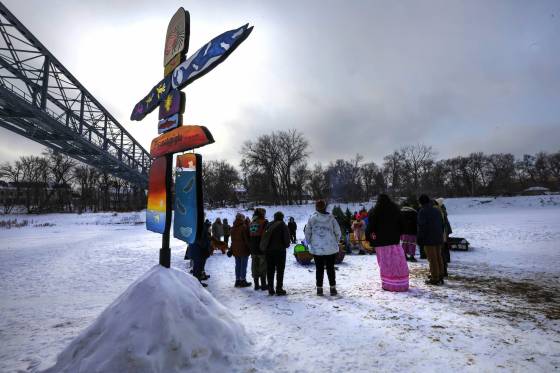 Members of the Villa Rosa community and Assiniboine River Art Knowledge keepers took part in a small ceremony on the Assiniboine River to honour for creating artwork, including four benches and an inukshuk (foreground) for the Wolseley Winter Wonderland River Trail. (Ruth Bonneville / Winnipeg Free Press)