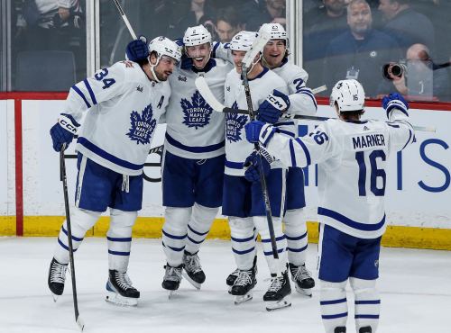 Toronto Maple Leafs' Auston Matthews (34), Simon Benoit (2), Jake McCabe (22), Matthew Knies (23) and Mitchell Marner (16) celebrate Benoit's goal during third period NHL action against the Winnipeg Jets in Winnipeg on Saturday, January 27, 2024. THE CANADIAN PRESS/John Woods
