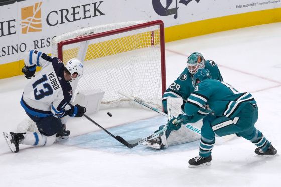 Jets centre Gabriel Vilardi (13) scores past San Jose Sharks goaltender Mackenzie Blackwood, top right, and defenceman Jan Rutta on Jan. 4. (Jeff Chiu / The Associated Press files)