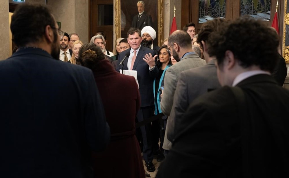 Reporters, staffers and Members of Parliament listen to Minister of Public Safety, Democratic Institutions and Intergovernmental Affairs Dominic LeBlanc speak about auto theft, Wednesday, February 7, 2024 in Ottawa. The federal government says an estimated 90,000 cars are stolen annually in Canada, resulting in about $1 billion in costs to Canadian insurance policy-holders and taxpayers. THE CANADIAN PRESS/Adrian Wyld