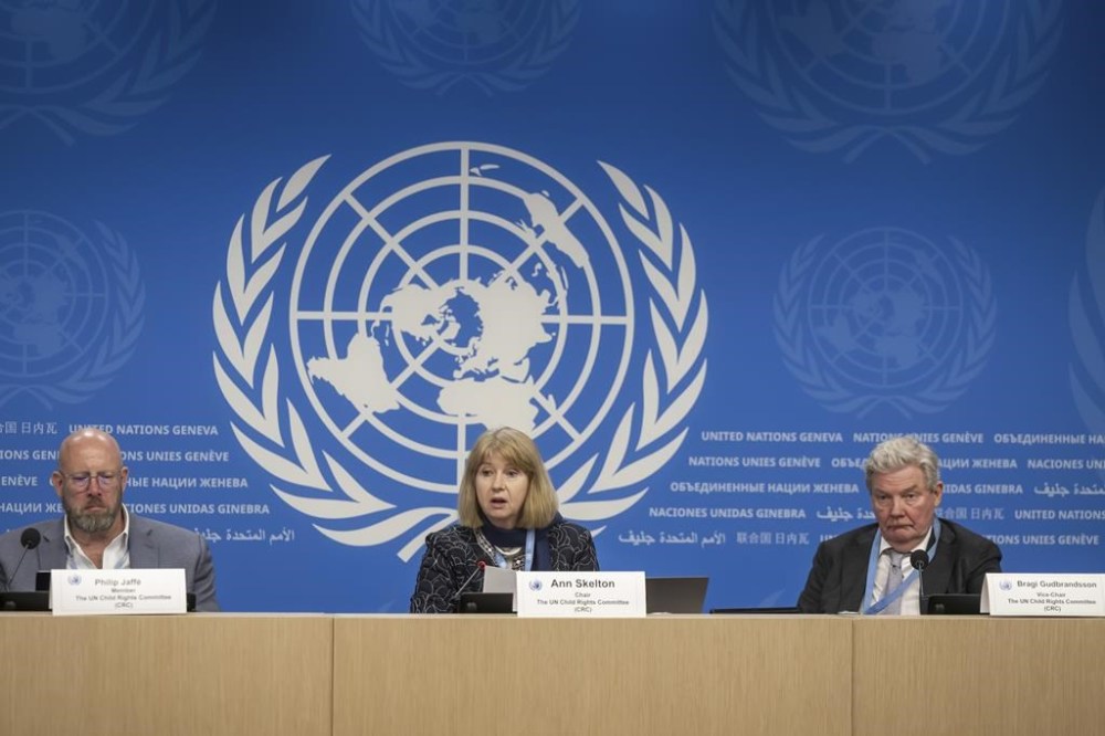 From left, member of the UN Committee on the Rights of the Child Philip Jaffe, Chair of the UN Committee on the Rights of the Child Ann Skelton, and Vice-Chair Bragi Gudbrandsson, present its findings on Bulgaria, Congo, Lithuania, Russia, Senegal and South Africa, during a press conference at the European headquarters of the United Nations in Geneva, Switzerland, Thursday, Feb. 8, 2024. A panel of U.N.-backed experts that focuses on children's human rights called Thursday on Russia to prevent efforts to rewrite school curricula and textbooks to reflect the government's “political and military agenda,” including over the war in Ukraine. (Martial Trezzini/Keystone via AP)