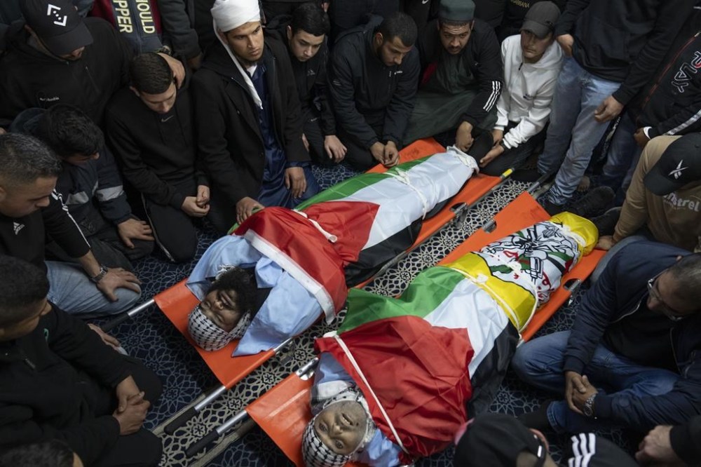 Mourners take the last look at the body of Ziad Da'meh, 39, right, and Islam al-Ali, 36, at a mosque during there funeral in the West Bank refugee camp of Nour Shams, Tulkarem, Thursday, Feb. 8, 2024. Palestinian health ministry said that two Palestinians were killed during an Israeli army operation in the refugee camp on Wednesday. (AP Photo/Nasser Nasser)