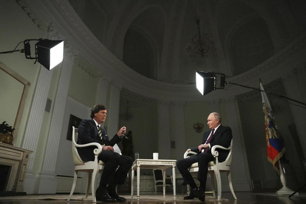 In this photo released by Sputnik news agency on Friday, Feb. 9, 2024, Russian President Vladimir Putin, right, listens to a question during an interview with former Fox News host Tucker Carlson at the Kremlin in Moscow, Russia, Tuesday, Feb. 6, 2024. (Gavriil Grigorov, Sputnik, Kremlin Pool Photo via AP)