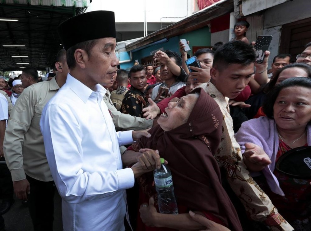FILE - Indonesian President Joko Widodo, left, listens to an elderly woman during his visit to Tanah Tinggi, a lower-income neighborhood, in Jakarta, Indonesia, on July 26, 2019. Widodo's phenomenal rise from a riverside slum, where he grew up, to the presidency of Indonesia spotlighted how far the world's third-largest democracy had veered from a brutal authoritarian era a decade ago. With his second and final five-year term ending in October, Widodo, regarded by some as Asia's Barack Obama, is leaving a legacy of impressive economic growth and an ambitious array of infrastructure projects including a $33 billion plan to relocate Indonesia's congested capital to the frontier island of Borneo. (AP Photo/Dita Alangkara, File)