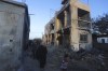 Palestinians walk by a residential building destroyed in an Israeli strike in Rafah, Gaza Strip, Sunday, Feb. 11, 2024. (AP Photo/Hatem Ali)