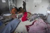 Palestinians kneel next to the bodies of relatives killed in the Israeli bombardment of the Gaza Strip, inside a morgue of Al Aqsa hospital, in Deir al Balah, Gaza Strip, Monday, Feb. 12, 2024. (AP Photo/Adel Hana)