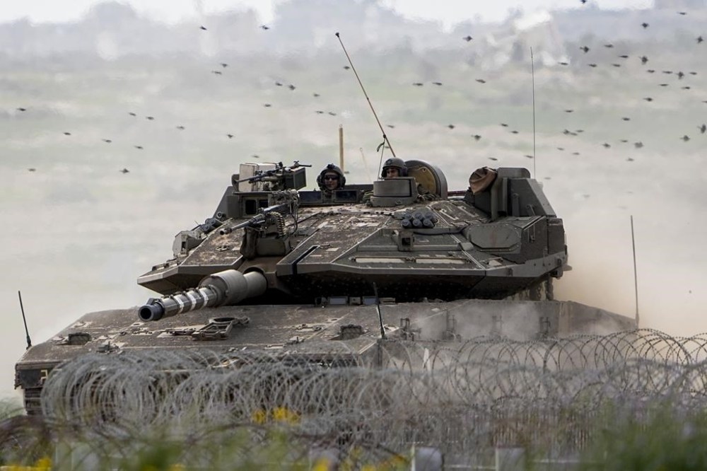 Israeli soldiers drive a tank on the border with the Gaza Strip, in southern Israel, Tuesday, Feb. 13, 2024. The army is battling Palestinian militants across Gaza in the war ignited by Hamas' Oct. 7 attack into Israel. (AP Photo/Ariel Schalit)