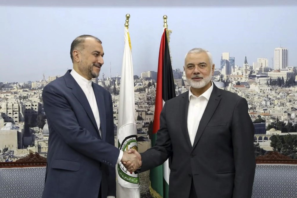 In this picture released by the Iranian Foreign Ministry, Iran's Foreign Minister Hossein Amirabdollahian, left, shakes hands with Hamas chief Ismail Haniyeh during their meeting in Doha, Qatar, Tuesday, Feb. 13, 2024. (Iranian Foreign Ministry via AP)