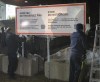 RCMP officers unwrap a new warning sign for asylum seekers on the border at Roxham Road from New York into Canada Saturday March 25, 2023, in Champlain, N.Y. RCMP have charged two Montreal men with conspiracy after they were allegedly caught trying to smuggle people across the border into the United States last year. THE CANADIAN PRESS/Ryan Remiorz