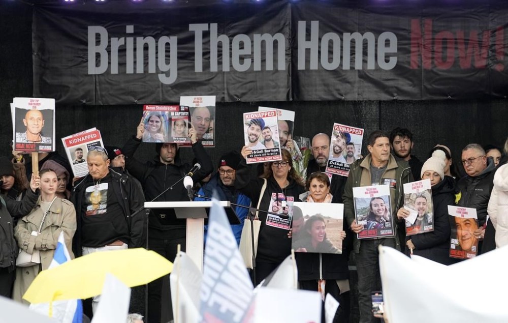 Families of hostages and former hostages hold images of the victims on a podium near the International Crime Court at The Hague, during a protest of representatives of families of hostages from the Oct. 7 cross-border attack by Hamas on Israel, in The Hague, Netherlands, Wednesday, Feb. 14, 2024. The Hostages Families Forum together with the Raoul Wallenberg Center for Human Rights is submitting a comprehensive complaint to the International Criminal Court on behalf of released hostages and families of hostages, including the issuance of arrest warrants for Hamas leaders on war crimes allegations including taking hostages, enforced disappearances, sexual violence and torture. (AP Photo/Martin Meissner)