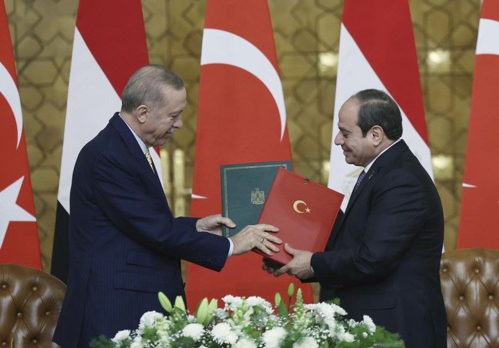 In this handout photo released by Turkish Presidency, Turkey's President Recep Tayyip Erdogan, left, and Egyptian President Abdel Fattah Al-Sissi, right, exchange signed agreements following their meeting at Al-Ittihadiya palace in Cairo, Egypt, Wednesday, Feb. 14, 2024. Edrogan held talks in Cairo on Wednesday with his Egyptian counterpart in efforts to rally support for growing demands in the region that Israel halt its war against Hamas in Gaza. (Turkish Presidency via AP)