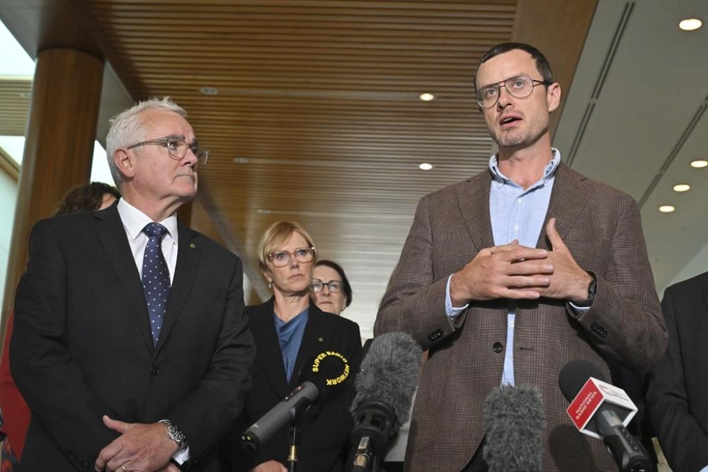 Independent member of parliament Andrew Wilkie, left, and Julian Assange's brother Gabriel Shipton, right, speak to the media at Parliament House in Canberra, Thursday, Feb. 15, 2024. Australia's House of Representatives has passed a motion calling on the United States and the UK to end the prosecution of WikiLeaks founder Julian Assange and for him to be allowed to return to his home country. (Mick Tsikas/AAP Image via AP) NO ARCHIVING