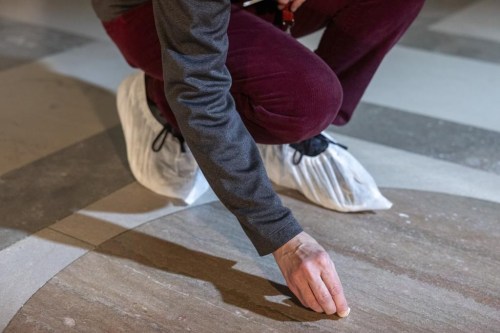 Amy Lubick, a supervisory conservator at the National Archives, rubs stained floors at National Archives with an eraser in Washington on Thursday, Feb. 15, 2024. The National Archives building and galleries were evacuated on Feb. 14 after two protesters dumped powder on the protective casing around the U.S. Constitution. (AP Photo/Amanda Andrade-Rhoades)