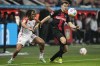 Bayern's Sacha Boey, left, and Leverkusen's Josip Stanisic challenge for the ball during the German Bundesliga soccer match between Bayer 04 Leverkusen and FC Bayern Munich at the BayArena in Leverkusen, Germany, Saturday, Feb. 10, 2024. (AP Photo/Martin Meissner)