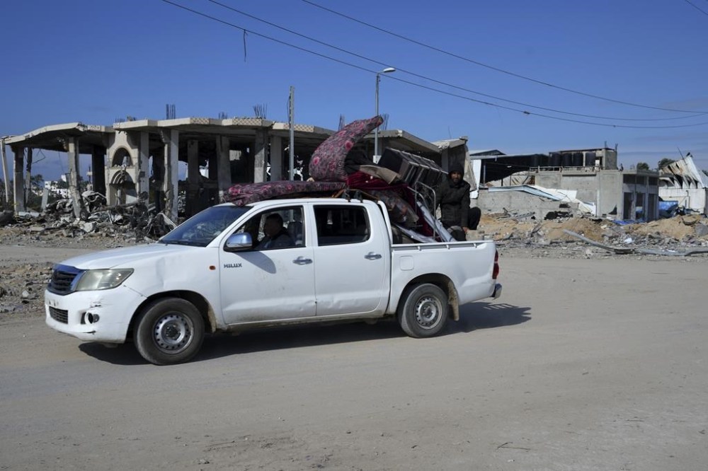 Palestinians ride their truck through destruction from the Israeli bombardment in the Maghazi refugee camp, central Gaza Strip, Friday, Feb. 16, 2024. (AP Photo/Adel Hana)
