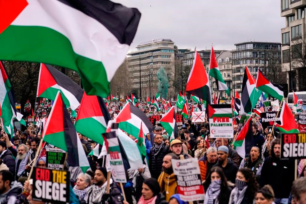 Protesters hold up flags and placards during a demonstration in support of Palestinian people in Gaza, in London, Saturday, Feb. 17, 2024. (AP Photo/Alberto Pezzali)