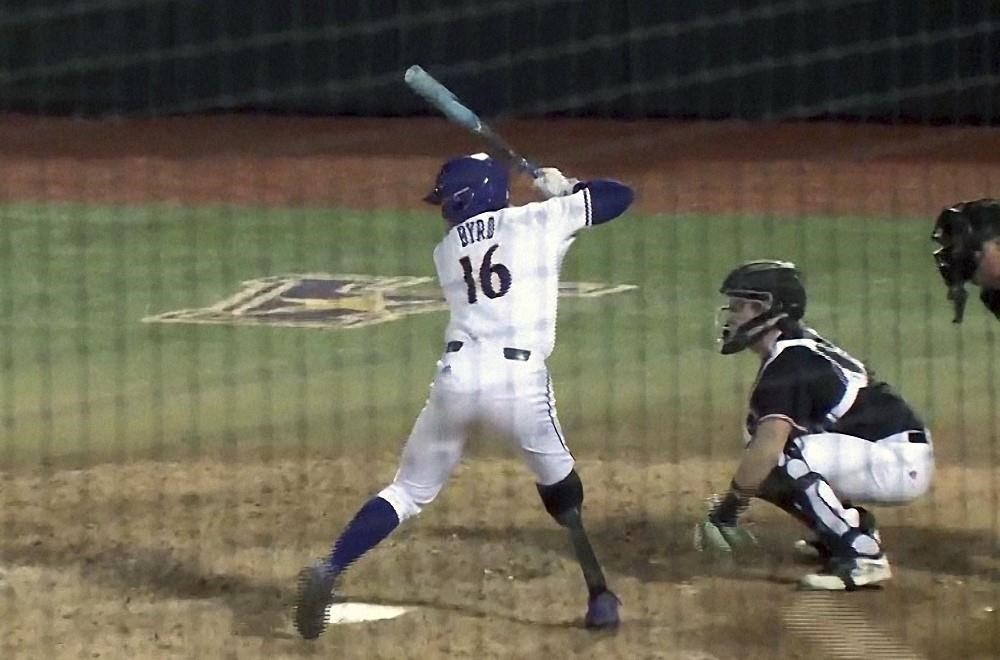 This image from video provided by WITN-TV shows Parker Byrd (16) during a baseball game in Greenville, N.C. East Carolina sophomore Parker Byrd appeared in Friday’s season-opening win against Rider with a prosthetic leg after having part of his right leg amputated following a 2022 boating accident. The school said he is the first NCAA Division I athlete to play in a game with a prosthetic leg. (WITN via AP)